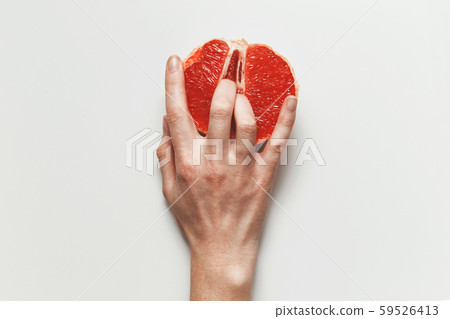 Sexual and female genital concept. Grapefruit and women's fingers like vagina and clitoris symbol 59526413