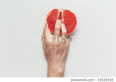 Sexual and female genital concept. Grapefruit and women's fingers like vagina and clitoris symbol 59526416