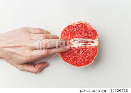 Sexual and female genital concept. Grapefruit and women's fingers like vagina and clitoris symbol 59526418