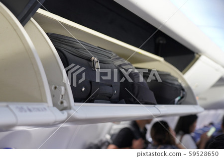 view of carry on luggage on overhead shelf in the 59528650