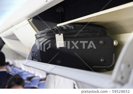 view of carry on luggage on overhead shelf in the 59528652