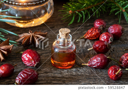 A bottle of rose hip seed oil with dried rose hips 59528847