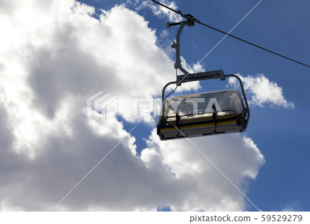 Chair-lift and sunlit sky with clouds at evening 59529279