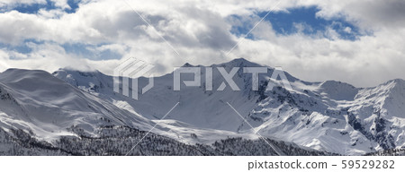 View on snowy mountains and cloudy sky in evening View on snowy mountains and cloudy sky in evening 59529282
