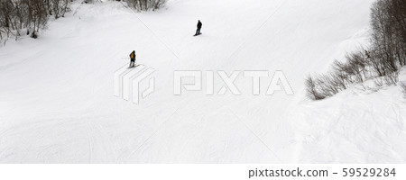 Skier and snowboarder downhill on ski slope at Skier and snowboarder downhill on ski slope at 59529284