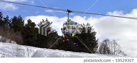 Skiers and snowboarders on chair-lift in winter Skiers and snowboarders on chair-lift in winter 59529307