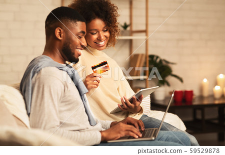 E-Commerce concept. African-american couple using laptop at home 59529878