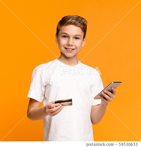 Cute teenager using mobile application and credit card Cute teenager using mobile application and credit card 59530633