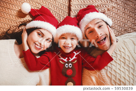 Top view of young family in santa hats laying down Top view of young family in santa hats laying down 59530839