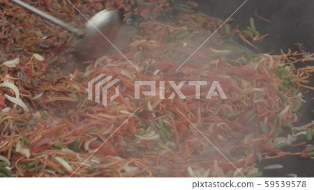 Asian mix of vegetables in liquid sauce is being stirred with a ladle in big wok Asian mix of vegetables in liquid sauce is being stirred with a ladle in big wok 59539578