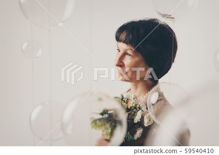 beautiful girl holding flowers on white background. March 8: woman among flowers. the concept of congratulations, women's holidays, natural make up beautiful girl holding flowers on white background. March 8: woman among flowers. the concept of congratulations, women's holidays, natural make up 59540410