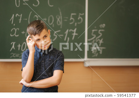 Cute boy stand in the classroom background of blackboard. Education. Elementary school 59541377