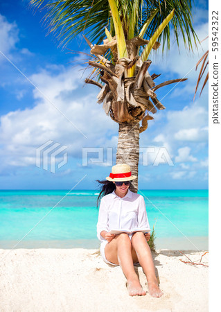 Young woman reading book during tropical white beach 59542322