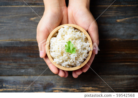 Cooked rice with quinoa seed in bowl holding by hand 59542568