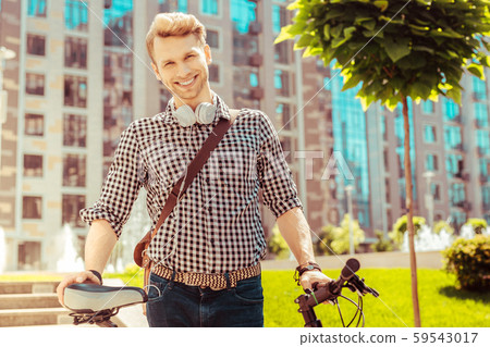 Positive delighted male going to ride bicycle 59543017