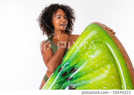 Pretty african female stands in swimsuit with rubber beach kiwi mattress and smiles isolated on Pretty african female stands in swimsuit with rubber beach kiwi mattress and smiles isolated on 59544221