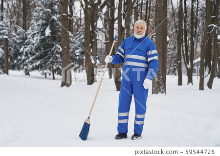 Cleaner in work overalls with broom. 59544728
