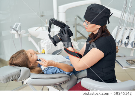 Dentist inspecting teeth of young girl. Dentist inspecting teeth of young girl. 59545142