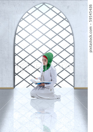 Asian Muslim woman in veil sitting and read the Koran 59545486
