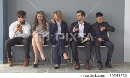 Recruitment to the company. Young applicants are awaiting interview. a group of young people bored Recruitment to the company. Young applicants are awaiting interview. a group of young people bored 59545780