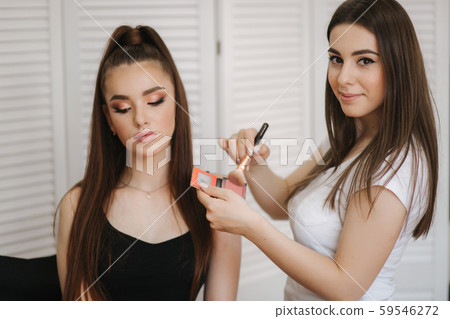 Female makeup master use a powder brush. Beautiful model in beauty studio. Professional make up Female makeup master use a powder brush. Beautiful model in beauty studio. Professional make up 59546272