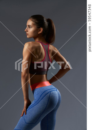 Side view of fitness girl in sportswear posing at camera Side view of fitness girl in sportswear posing at camera 59547348