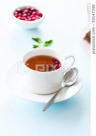 Tea with cranberry on a light blue background. 59547398