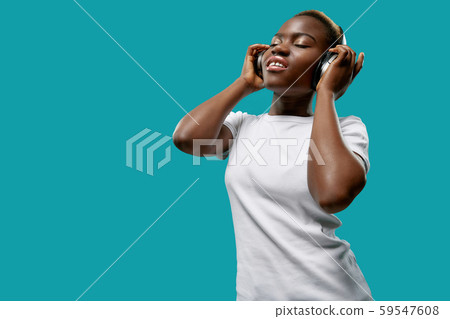 African woman in bluetooth headphones and enjoying music African woman in bluetooth headphones and enjoying music 59547608