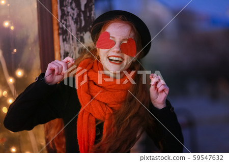 Red hair girl on the background of bright New Year's showcases having fun and posing with cardboard Red hair girl on the background of bright New Year's showcases having fun and posing with cardboard 59547632