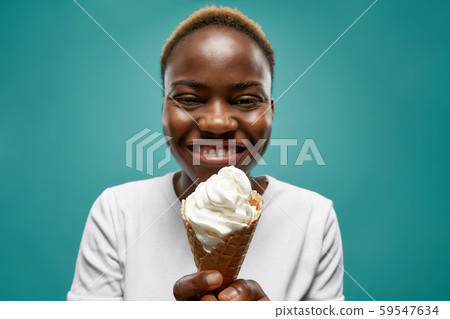 Selective focus of african woman eating ice cream in summer Selective focus of african woman eating ice cream in summer 59547634