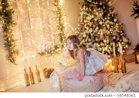 Little girl on the background of the fireplace and New Year tree Little girl on the background of the fireplace and New Year tree 59548561