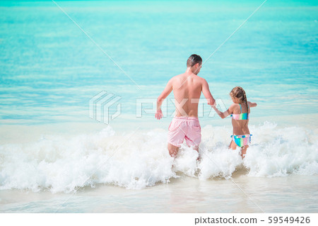 Little girl and happy dad having fun during beach vacation 59549426