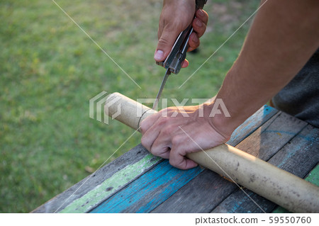 Men's hands sawing bamboo saw 59550760