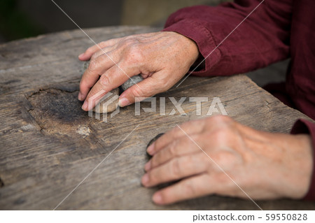 The old woman's hands are guessing on the stone The old woman's hands are guessing on the stone 59550828