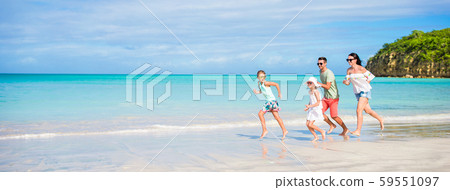 Beautiful happy family running on the seashore Beautiful happy family running on the seashore 59551097