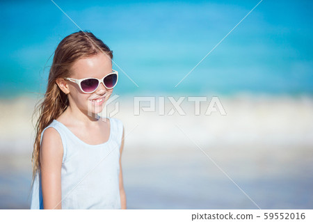 Beautiful little girl in sunglasses at beach having fun. Funny girl enjoy summer vacation. Beautiful little girl in sunglasses at beach having fun. Funny girl enjoy summer vacation. 59552016
