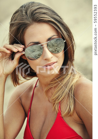 Young beautiful woman in red bikini and sunglasses Young beautiful woman in red bikini and sunglasses 59552393