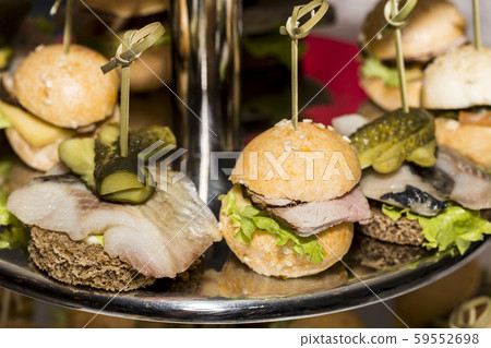 Miniature canapes with meat, vegetables and fish on steel banquet racks. Miniature canapes with meat, vegetables and fish on steel banquet racks. 59552698