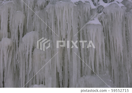 Background Icicles of ice in the winter of a frozen waterfall Background Icicles of ice in the winter of a frozen waterfall 59552715