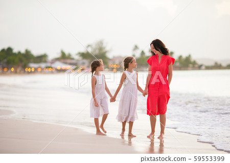 Adorable little girls and young mother on white beach Adorable little girls and young mother on white beach 59553399