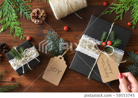 自然設計包裝聖誕禮物包裝紙和紅色指甲女手 59553745