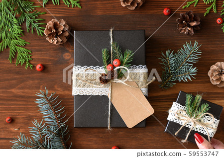 Natural design packaging Christmas gift wrapping and red manicure female hands 59553747