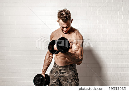 Strong man doing exercise with dumbbells Strong man doing exercise with dumbbells 59553985