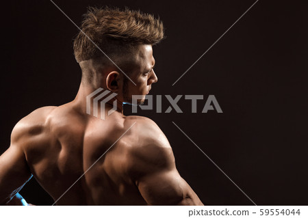 Strong Athletic Man Fitness Model posing back muscles, triceps, latissimus over black background 59554044