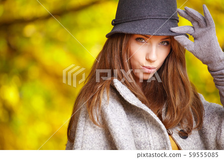 Fashionable woman with autumn leaves in hand and 59555085