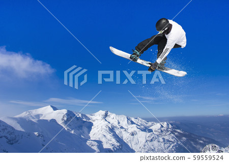 Skier Snowboarder jumping through air with sky in 59559524