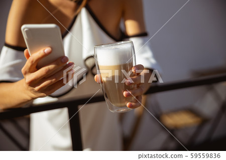 Woman having her morning coffee and texting 59559836