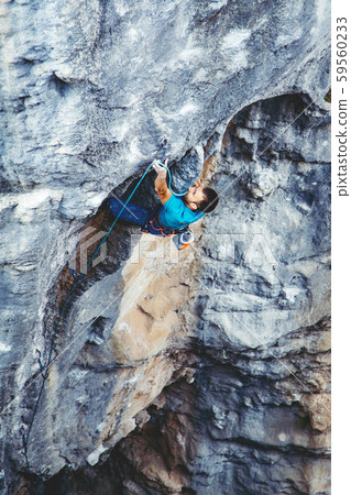 Man climbing a rock. 59560233