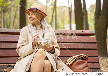 Cheerful stylish business lady having lunch outdoors Cheerful stylish business lady having lunch outdoors 59560648