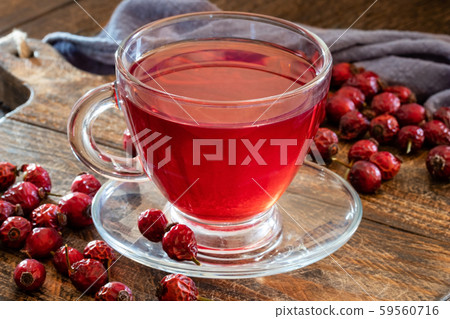 A cup of herbal tea with dried rose hips on a table A cup of herbal tea with dried rose hips on a table 59560716